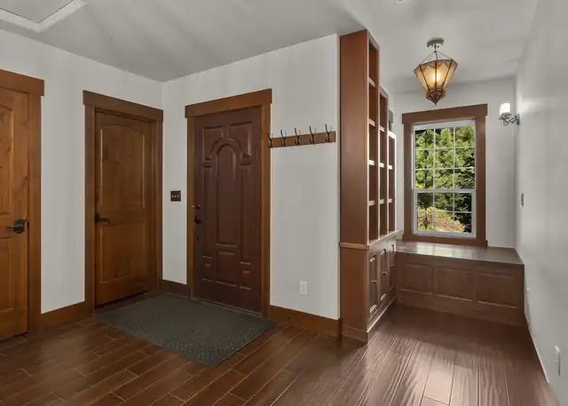 Home addition in Monroe, WA with stained wood doors and trim, a window seat nook and a lantern pendant