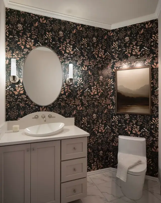 Moody half bath in Lake Stevens, WA with dark floral wallpaper, oval mirror, gray vanity and marble-look floor