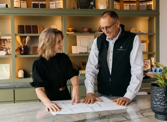 Jennifer and Ron VanderBeken reviewing floor plans at a kitchen island